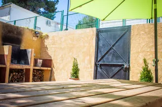 Mesa de merendero en el patio junto sombrilla | Casa Amparo