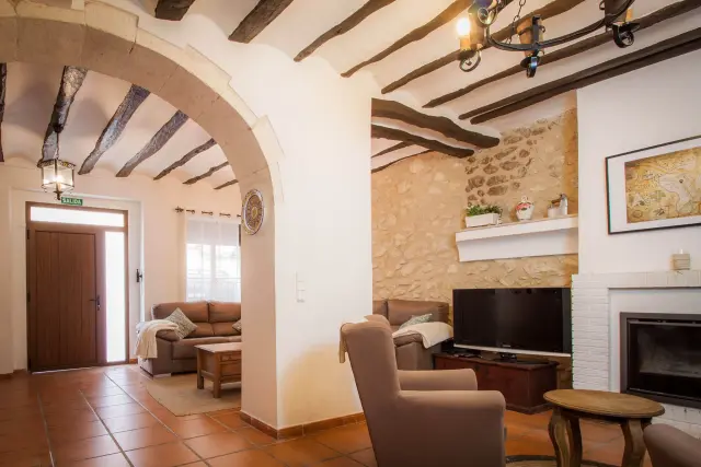 El salón con la chimenea y el arco de piedra
